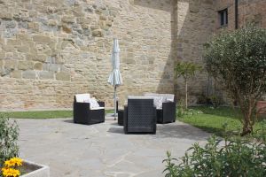 Uno spazio esterno confortevole con sedie e ombrellone, perfetto per momenti di tranquillità.