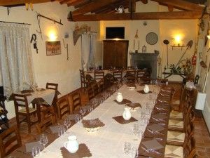 Spazio per la cena in un palazzo, arredato con tavoli disposti in modo ordinato e decorazioni essenziali.