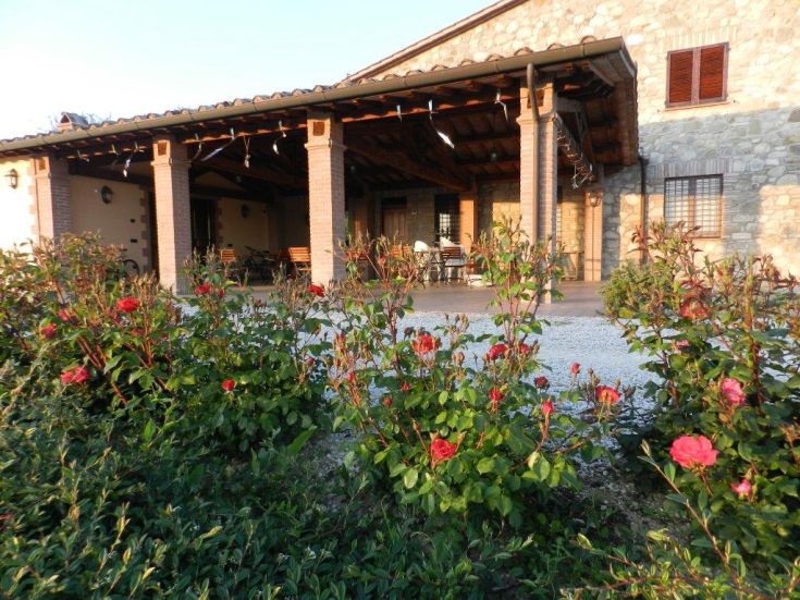 Ein gut gepflegtes Agriturismo mit einem schönen Garten, der die typische umbrische ländliche Architektur zeigt.