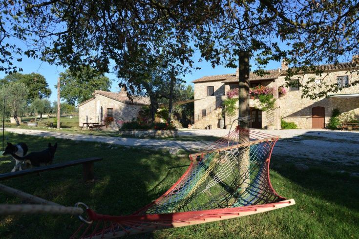 Une ferme paisible à la campagne, entourée de verdure et d'une structure simple.