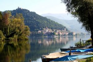 Un panorama tranquillo del Lago di Piediluco, circondato da montagne e vegetazione , con barche ormeggiate.