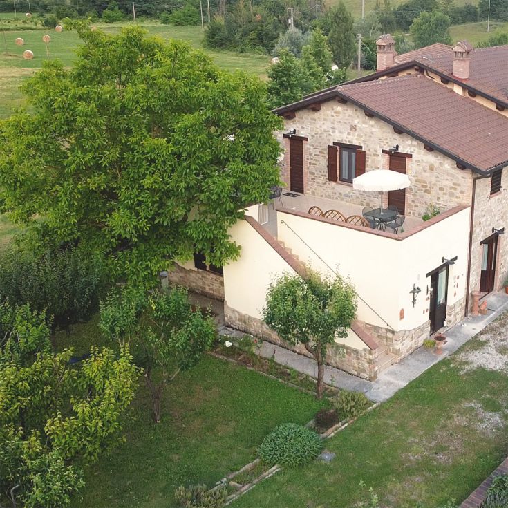 A renovated building in Umbria, featuring apartments, a garden, and spaces for families and pets.