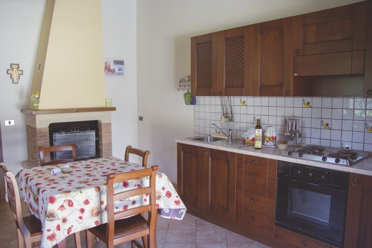Simple wooden kitchen with a dining table and fireplace, perfect for moments together.