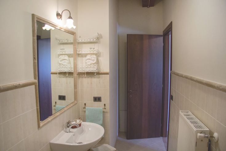A simple bathroom with a mirror and pleasant details, perfect for relaxation moments.
