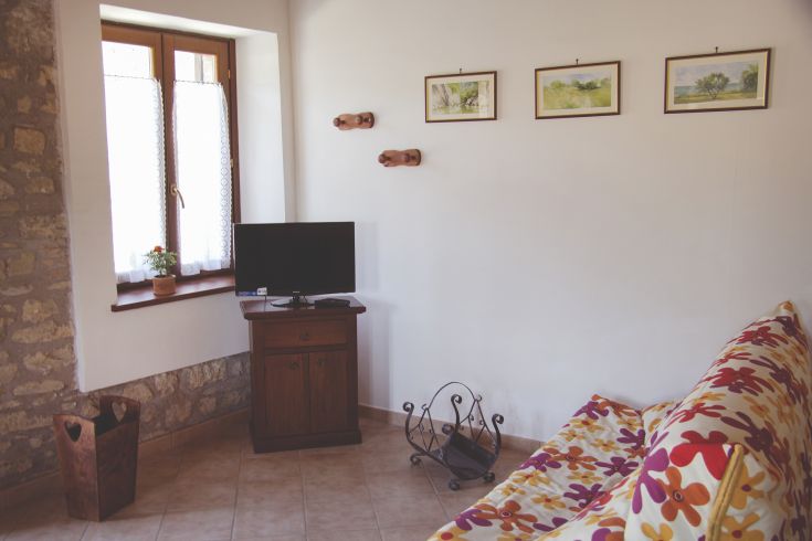 Cozy living room with floral decorations and large windows allowing natural light in.
