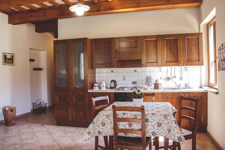 Bright and spacious kitchen with light wooden furniture and vibrant decor, ideal for meals with friends.