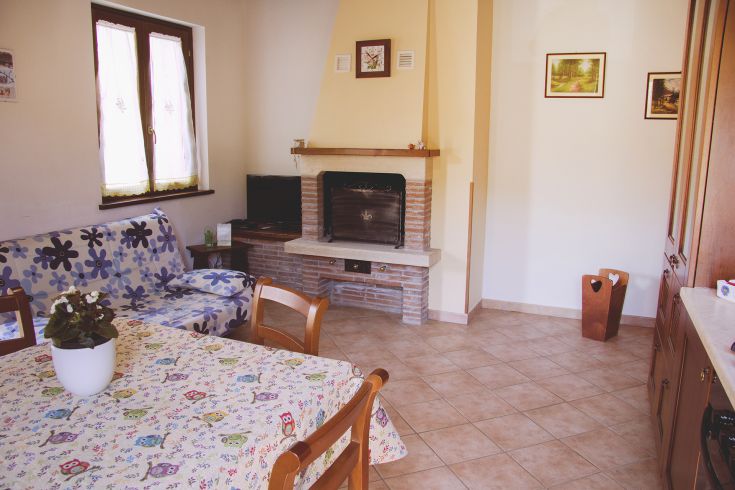 Cozy interior with a fireplace, floral sofa, and table. A serene space that feels like home.