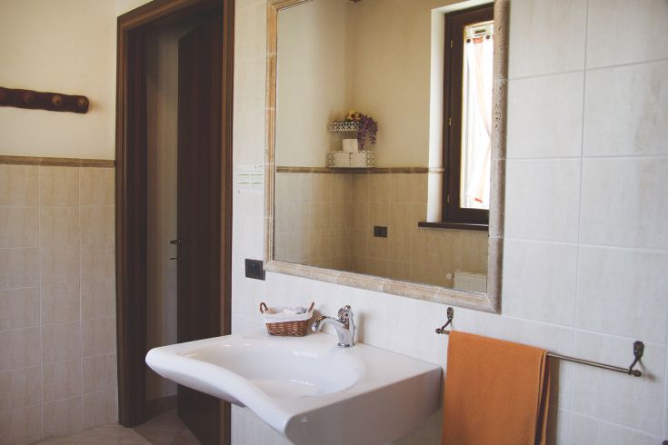 A spacious and well-lit bathroom featuring a simple sink and functional accessories.