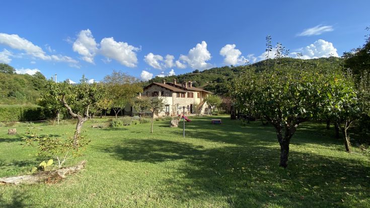 A rural building with a garden and fruit trees nestled among the Umbrian hills, ideal for a relaxing stay.