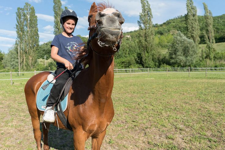 A girl riding a horse in a calm and serene natural environment.