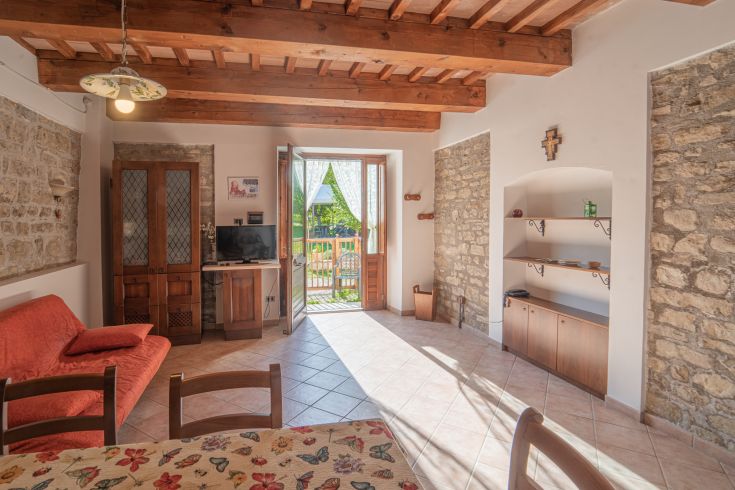 A simple, private space featuring a living area with garden access, perfect for relaxation moments.