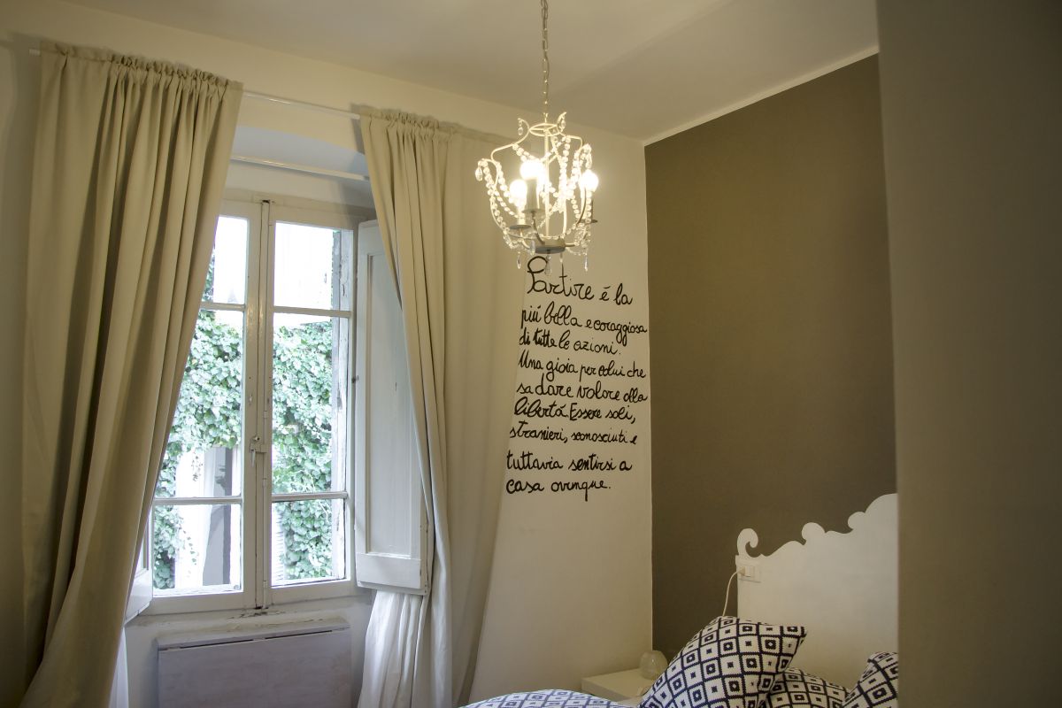 Stanza confortevole del B&B Alle Naiadi con decorazioni sulle pareti e illuminazione soft.