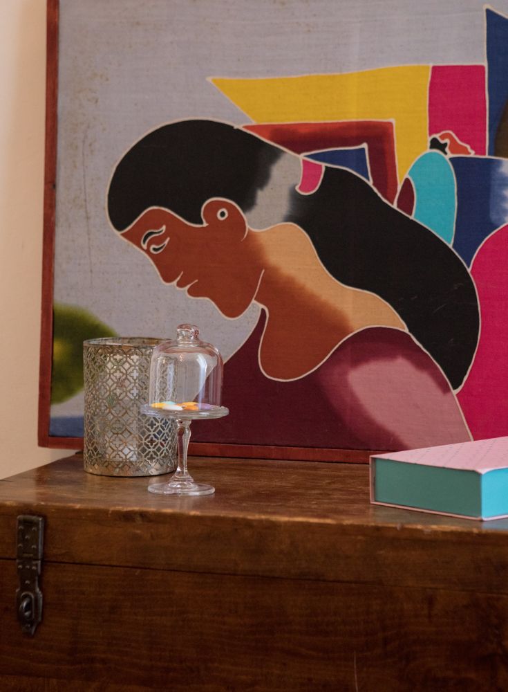 A simple indoor space featuring a lamp and a decorative candle on a table.