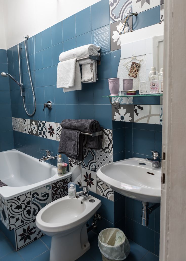 A modern bathroom with colorful ceramic tiles, featuring a bathtub and shower, perfect for relaxation.