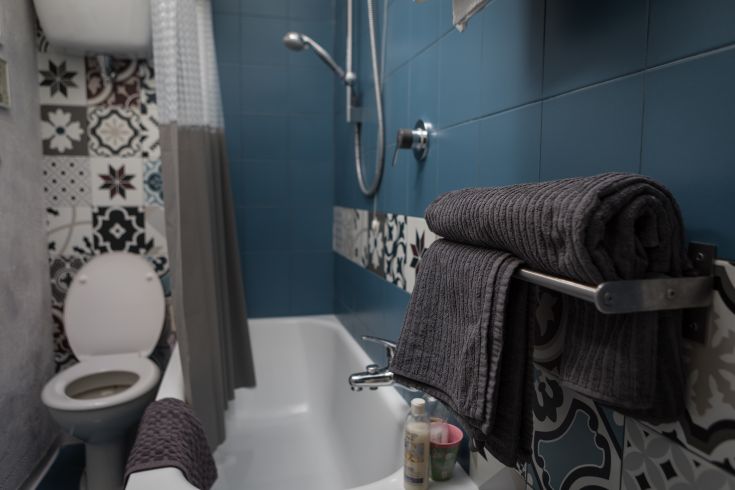 A simple bathroom with colorful tiles and a comfortable shower, perfect for relaxing moments.