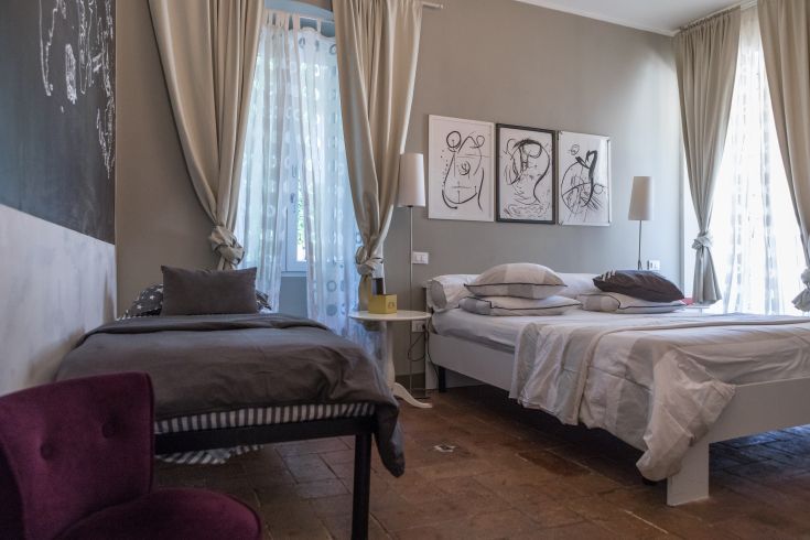 Simple room in a B&B in Umbria, featuring wall decorations and good natural lighting.
