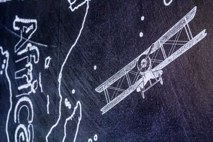 An airplane flies over a geographical representation of Africa, showcasing diverse landscapes and nature.