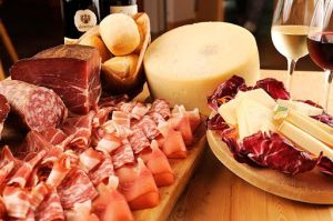 Un vassoio di salumi e formaggi, accompagnato da pane, perfetto per una cena in compagnia.