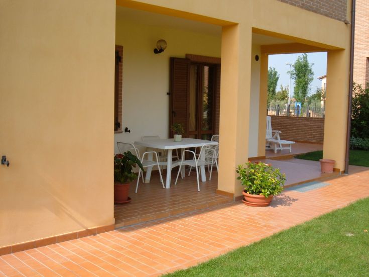 Außenbereich eines gemütlichen B&B mit einem Tisch und Pflanzen, umgeben von üppigem Grün.