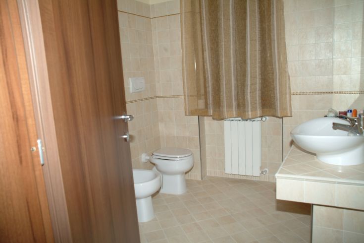 Einfaches und funktionales Badezimmer eines B&B, mit gut erhaltenen Möbeln und natürlichem Licht.