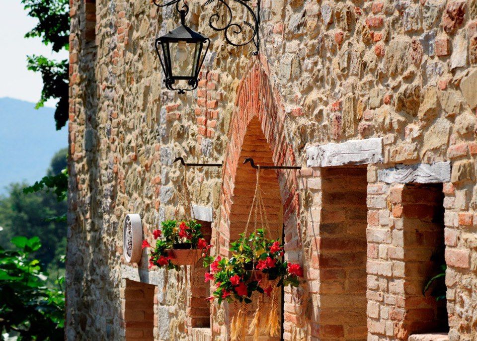 Façade en pierre ornée de fleurs vibrantes à l'entrée principale.