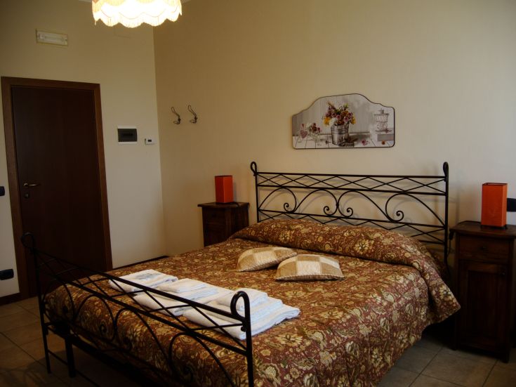 Simple bedroom with a double bed and wooden furniture. A calm and comfortable environment.