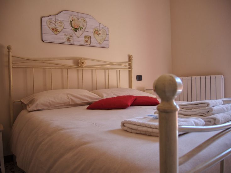Simple bedroom featuring a double bed and understated decorations.