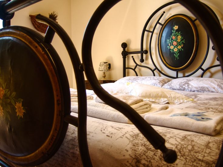 Comfortable room with a wrought iron bed and neatly arranged bedding.
