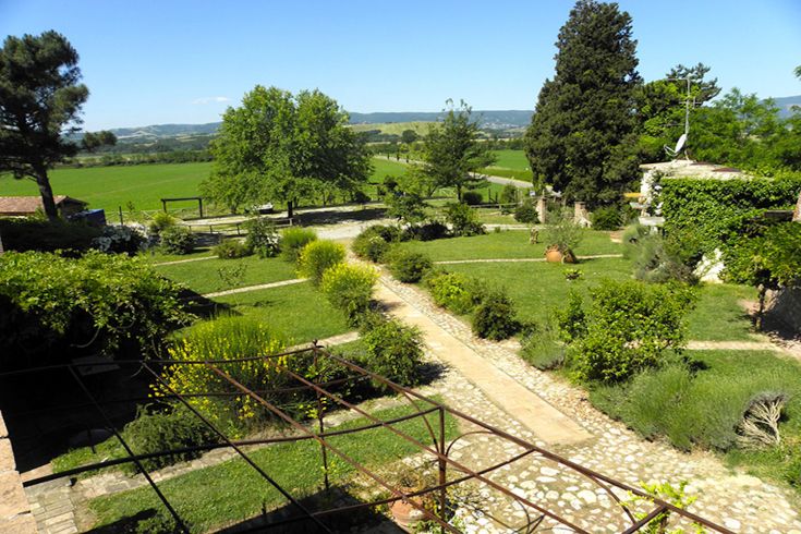 Eine ruhige Ecke der umbrischen Landschaft mit üppigen grünen Feldern und gut gepflegten Wegen.