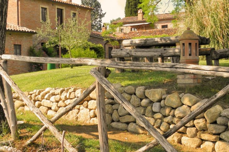 Ein historisches Dorf, umgeben von grünen Hügeln in der umbrischen Landschaft.