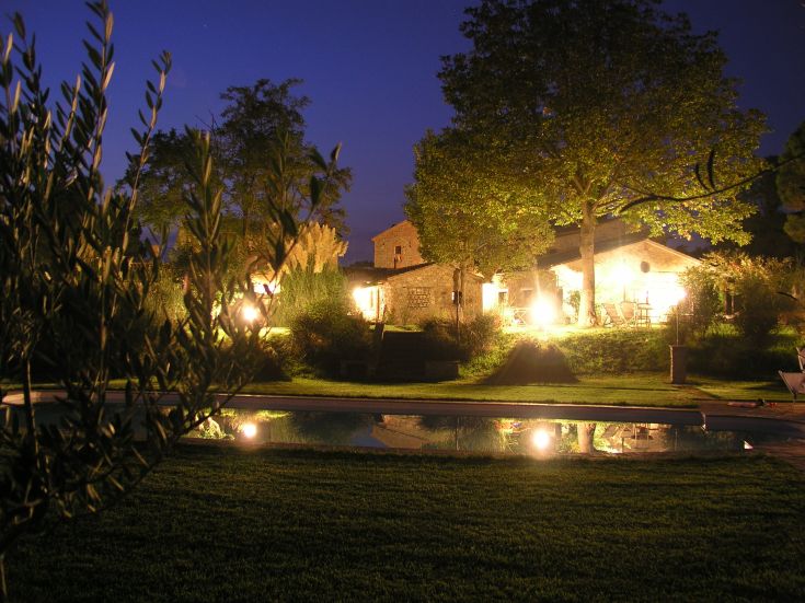 Ein historisches Dorf, umgeben von Grün, perfekt für Ruhe und Spaziergänge. Die Abendstimmung ist von Lichtern im Garten geprägt.
