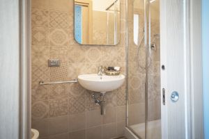 Bagno semplice con piastrelle decorate e finiture contemporanee. Uno spazio per il relax domestico.