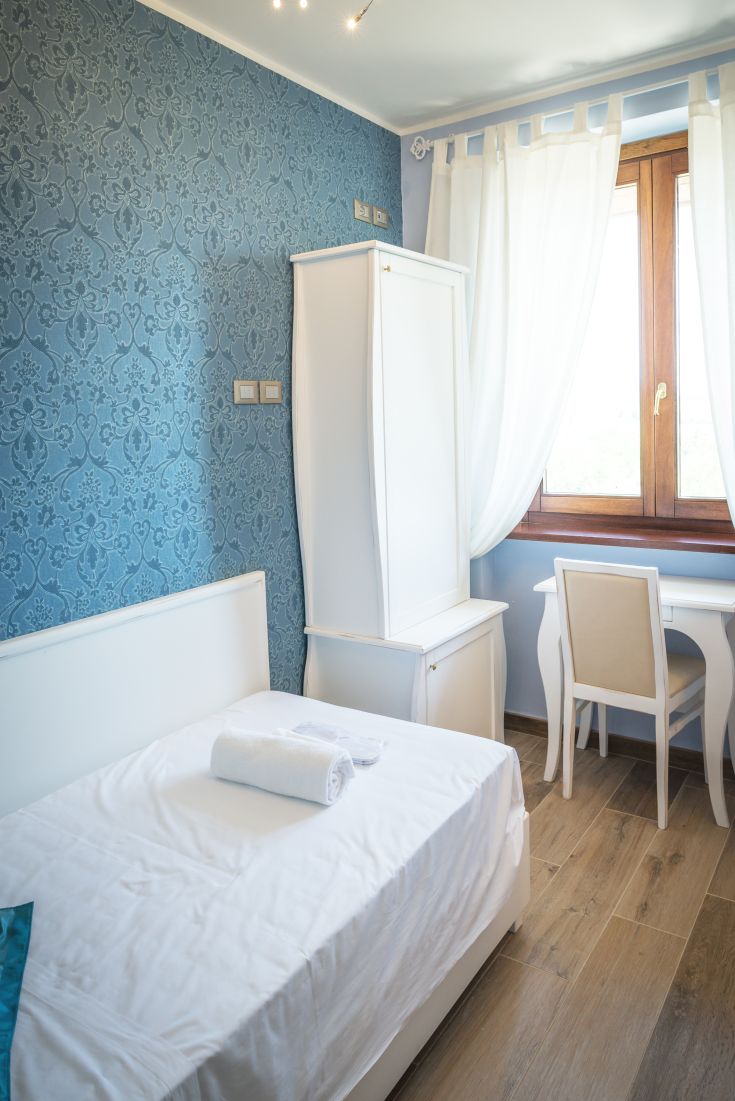 Stanza con pareti blu e mobili bianchi, offre un'atmosfera tranquilla e confortevole, ideale per momenti di relax.