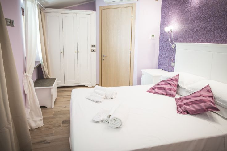 Camera confortevole con arredi semplici e colori tenui. Un ambiente sereno per un piacevole relax.