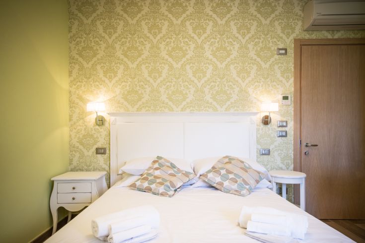 Camera dal design semplice con dettagli verdi, perfetta per il relax e un ambiente confortevole.