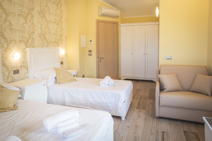 Camera di un B&B con letti singoli e arredamento semplice e confortevole.