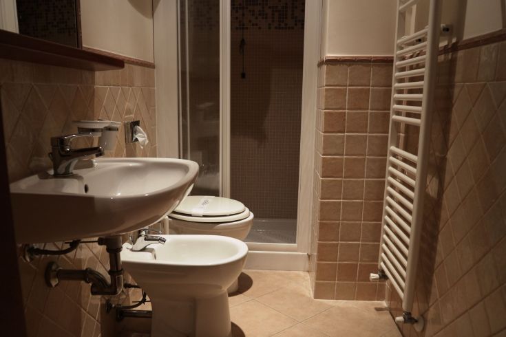 Une salle de bain simple et fonctionnelle avec des équipements contemporains, une douche et des carreaux aux tons neutres, idéale pour un moment de détente.