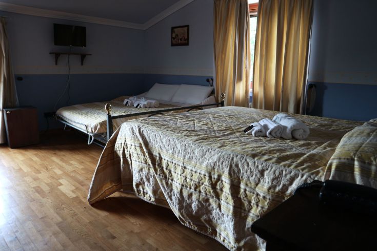 Une chambre simple dans une ferme, équipée de lits et de meubles essentiels pour un séjour agréable.