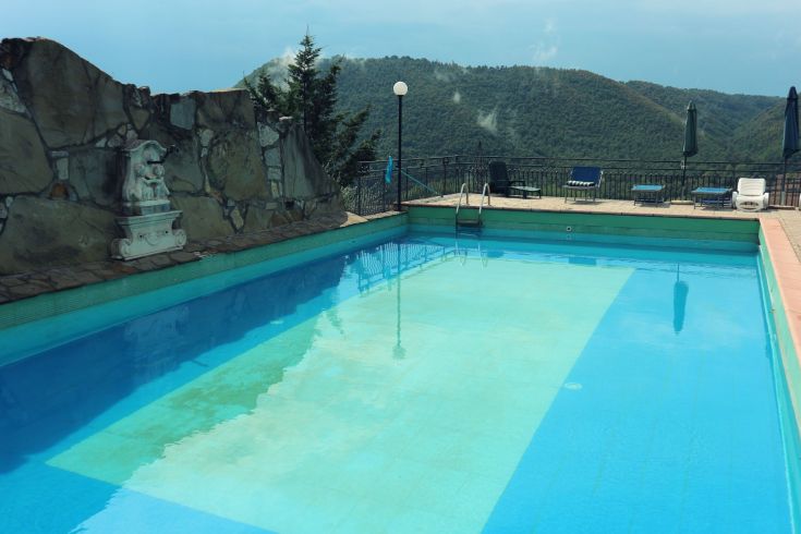 Une piscine entourée de la végétation luxuriante des collines ombriennes, un endroit paisible pour se détendre.