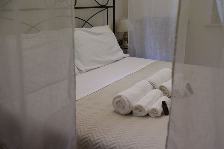 Chambre accueillante et tranquille avec un lit double et des draps blancs.