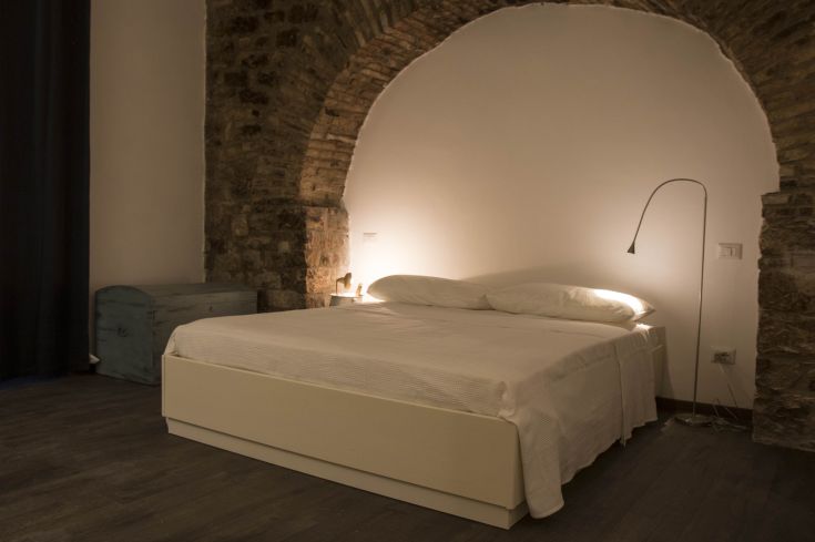 Comfortable room with a double bed and minimal decorations, a peaceful retreat in Umbria.