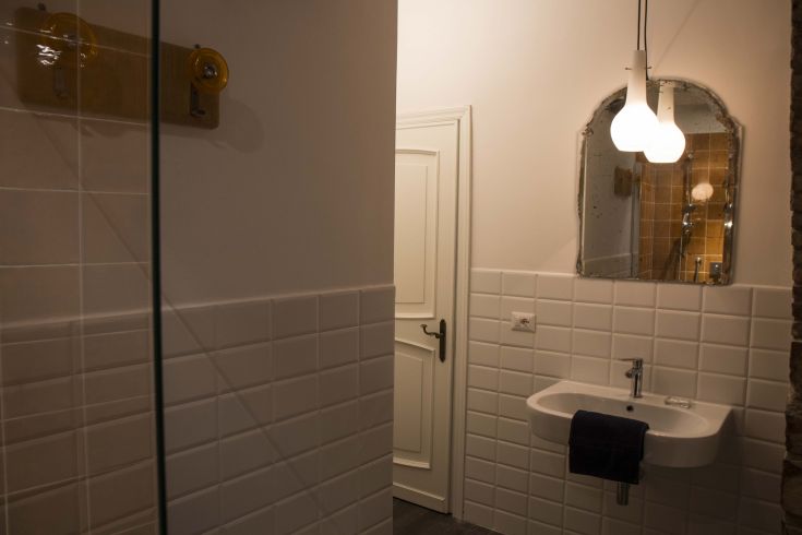 A modern bathroom in a B&B, featuring white tiles and simple furnishings.