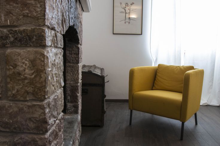 Simple interior with a yellow sofa and a brick fireplace.