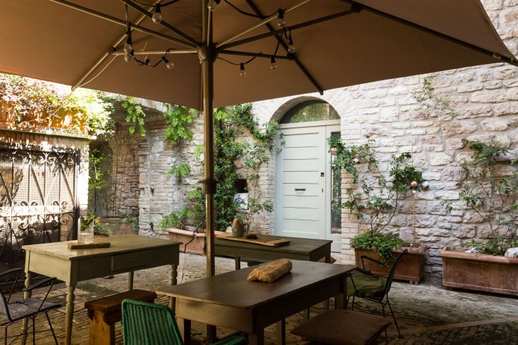 A relaxed corner with wooden tables, surrounded by plants and a private atmosphere.