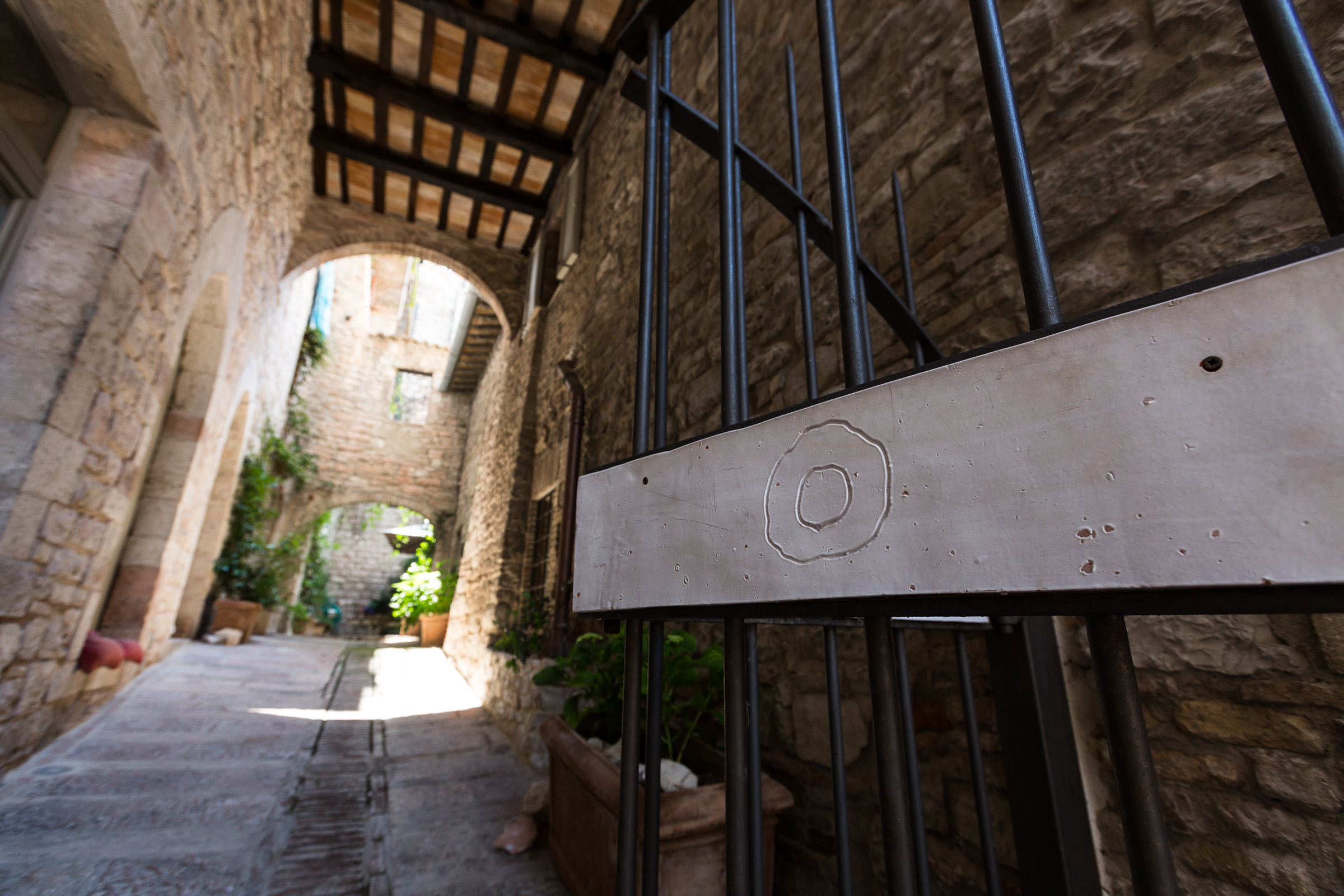 Un corridoio semplice nel centro della città, caratterizzato da muri in pietra e un ambiente riservato.