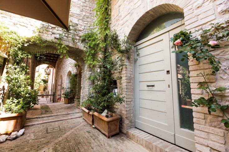 A peaceful courtyard scene in Umbria with green plants and an inviting door.