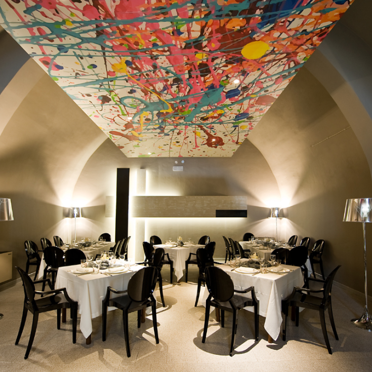 Ristorante accogliente con soffitto decorato da elementi colorati.