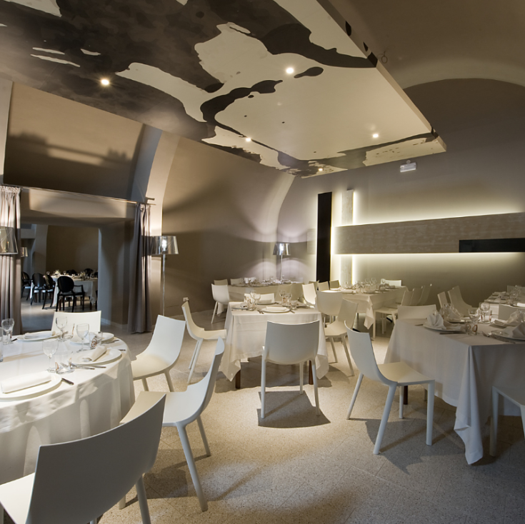 Interno di un ristorante con un design semplice, tavoli ben disposti e un'atmosfera accogliente.