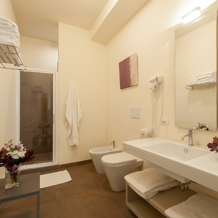 Un bagno in stile moderno con una doccia, un lavabo funzionale e arredamenti a tema floreale.