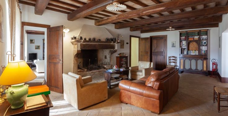 A cozy living room with exposed beams and a fireplace, perfect for relaxation and gatherings.
